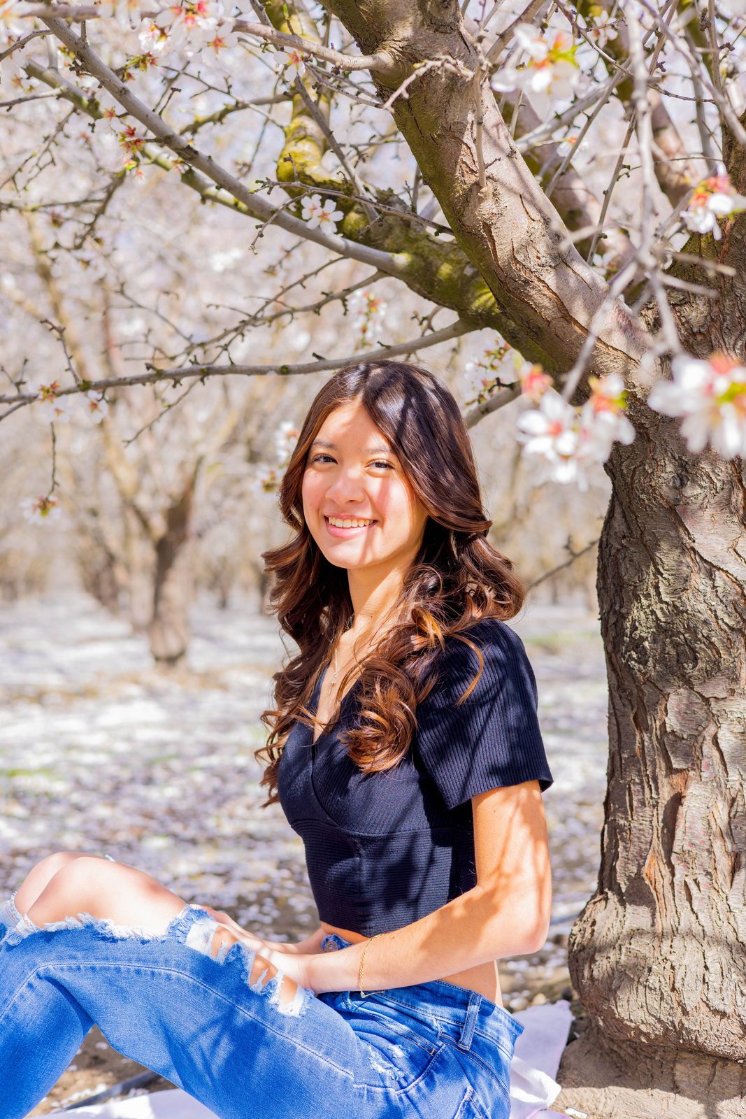 Senior seated beneath a blossoming tree