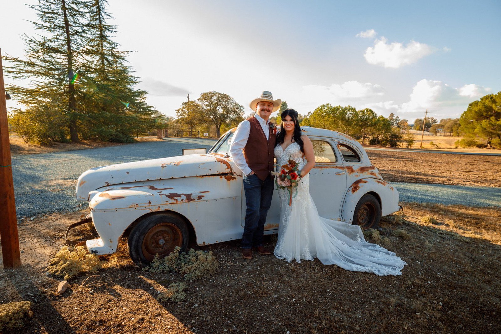 A couple photographed beside a vintage car
